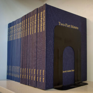 Two-Part motets booklets lined up on a bookshelf
