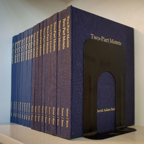 Two-Part motets booklets lined up on a bookshelf